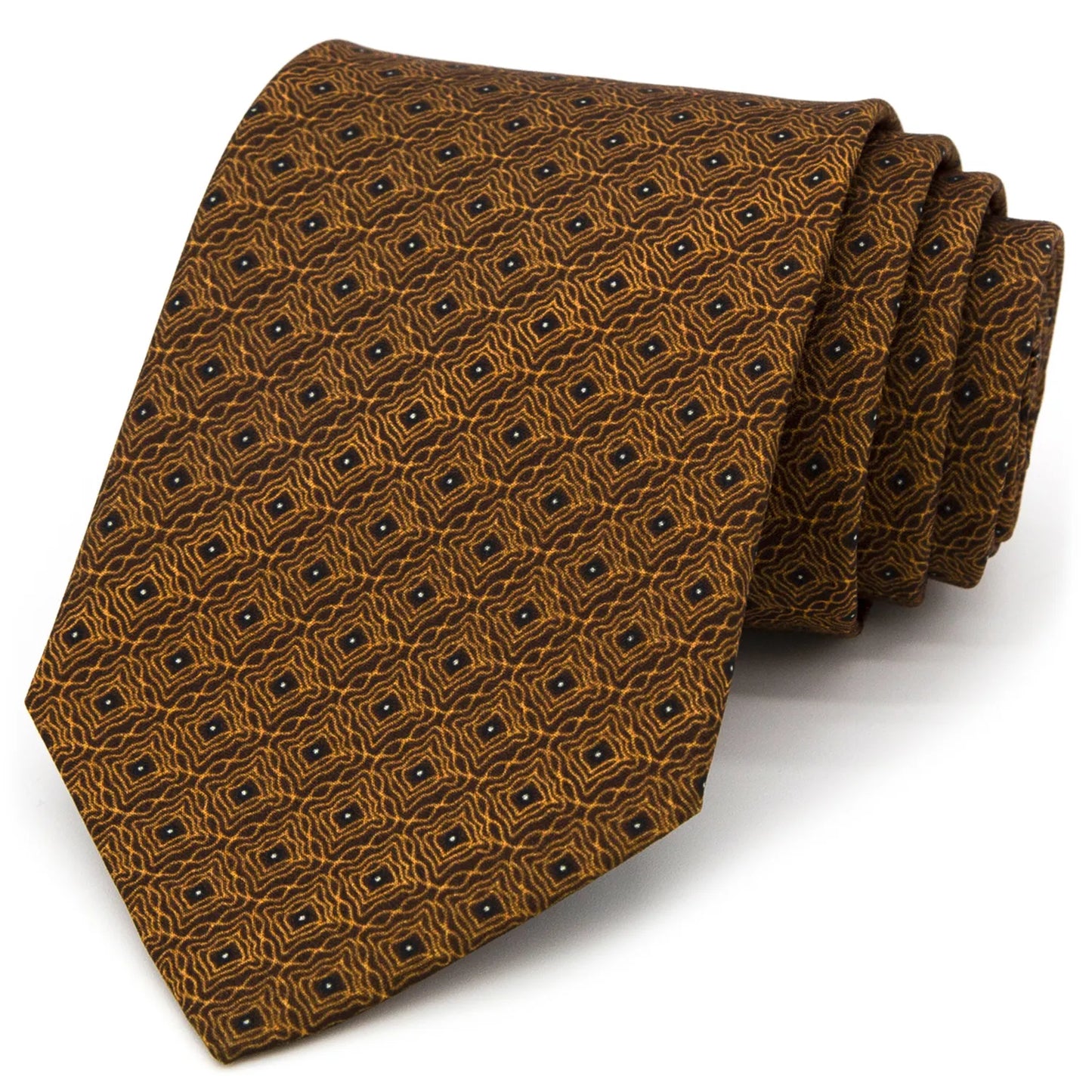 A brown men's necktie with a repeating geometric pattern in gold and dark blue is tied in a Windsor knot on a white collared shirt under a navy blue suit jacket.