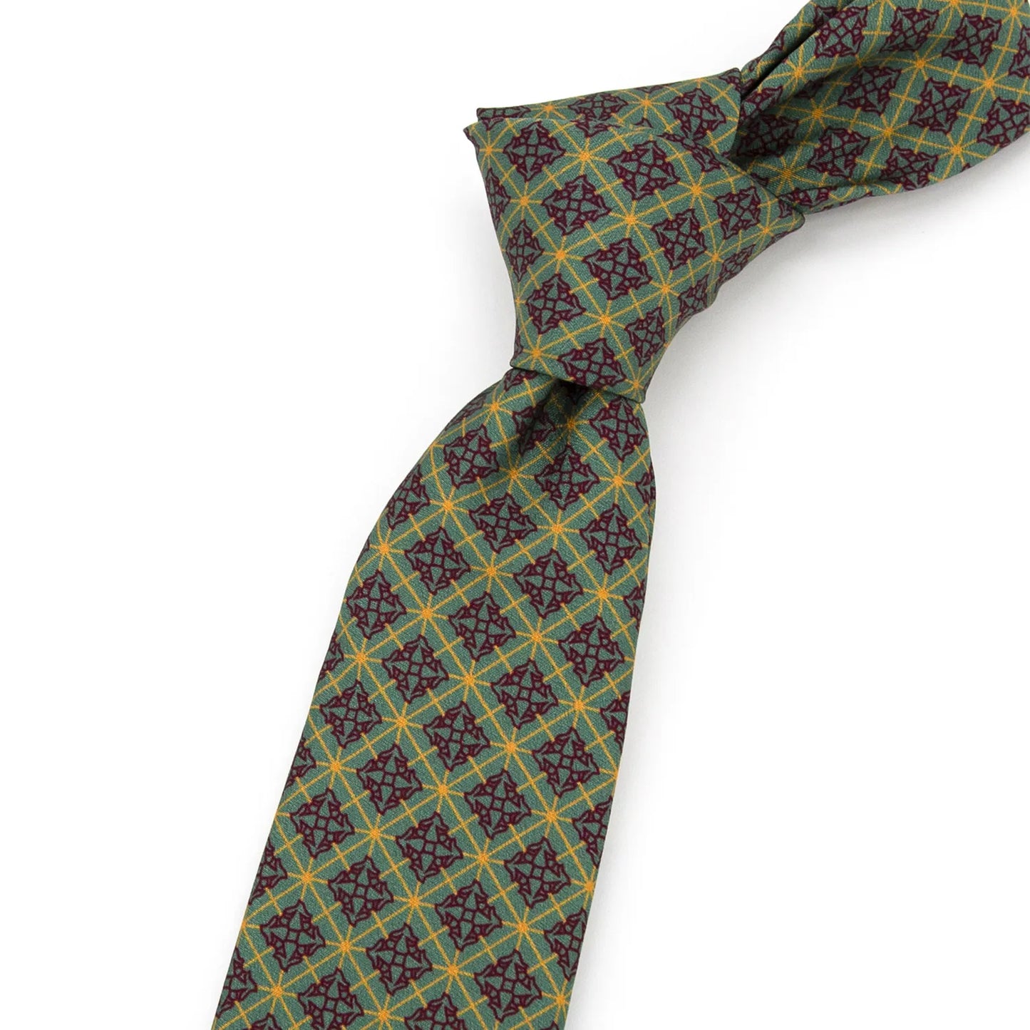A neatly folded green men's necktie showcasing its detailed vintage geometric pattern in red and gold against a plain white surface.