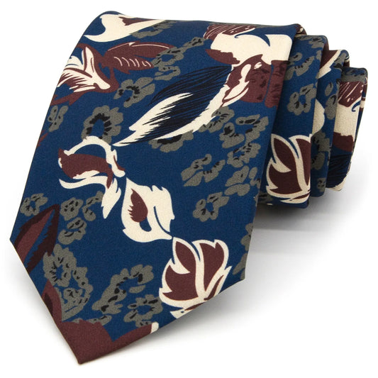 A dark blue men's necktie featuring a vintage-inspired floral pattern in beige, brown, and grey is casually knotted against a white background.