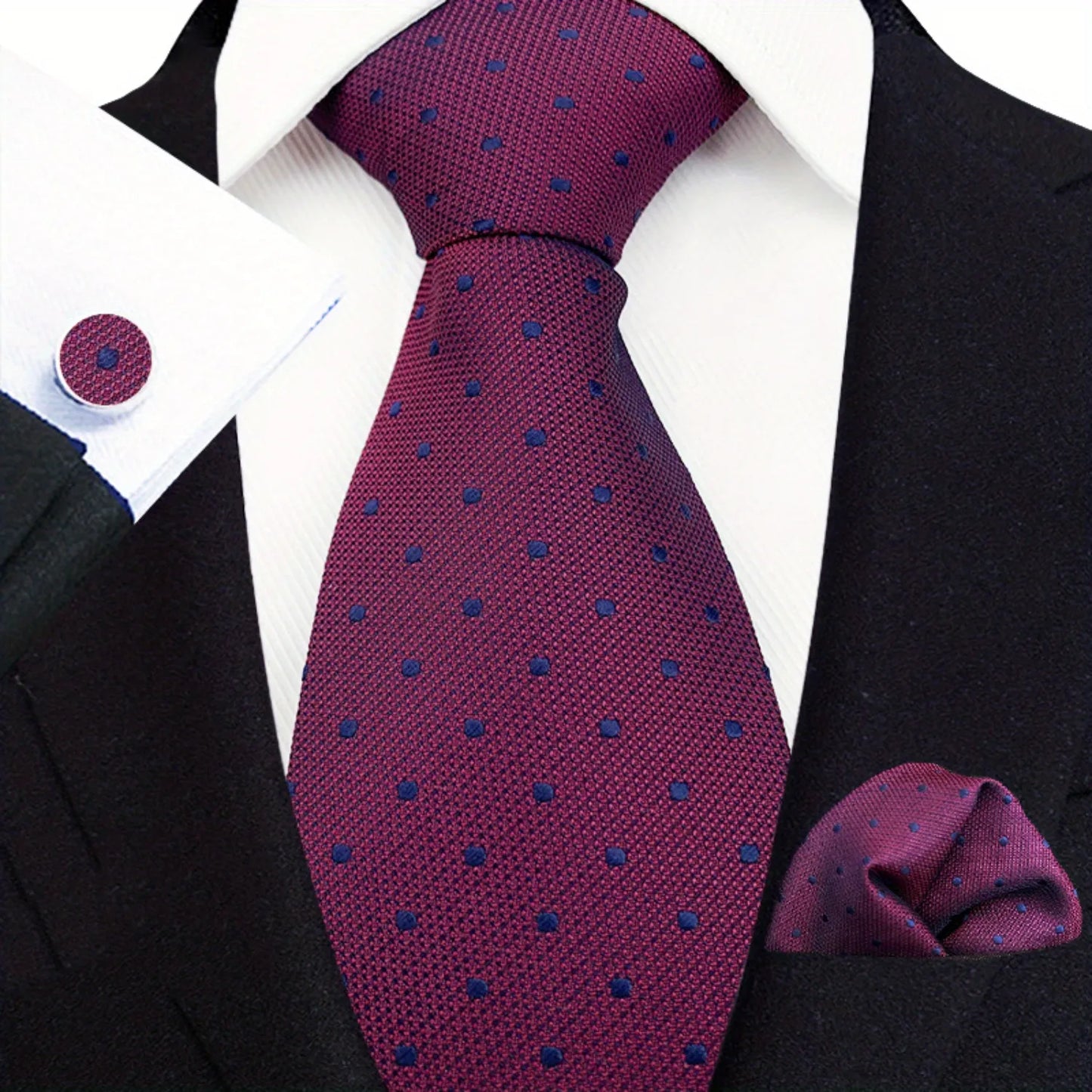 A set comprising a purple necktie with a dotted pattern, a matching pocket square, and a pair of cufflinks, displayed on a mannequin wearing a black suit and a white shirt.