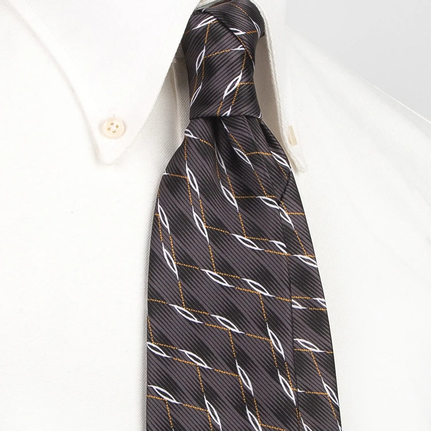A neatly rolled dark grey men's necktie showcasing its contemporary curved grid design in white and gold against a clean white backdrop.