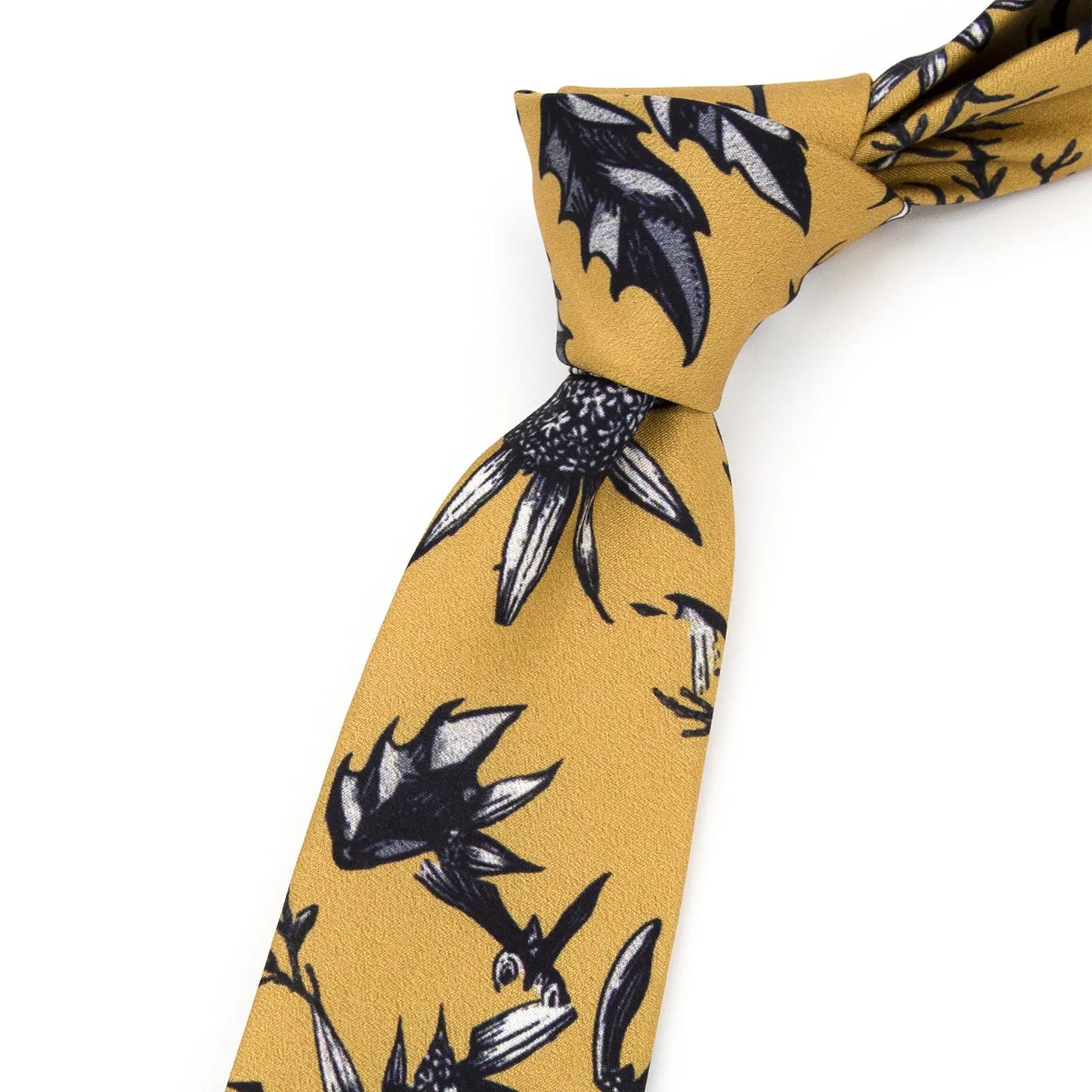 A neatly rolled mustard yellow men's necktie displaying its unique botanical pattern with black and white thistle and cotton plant illustrations against a clean white surface.