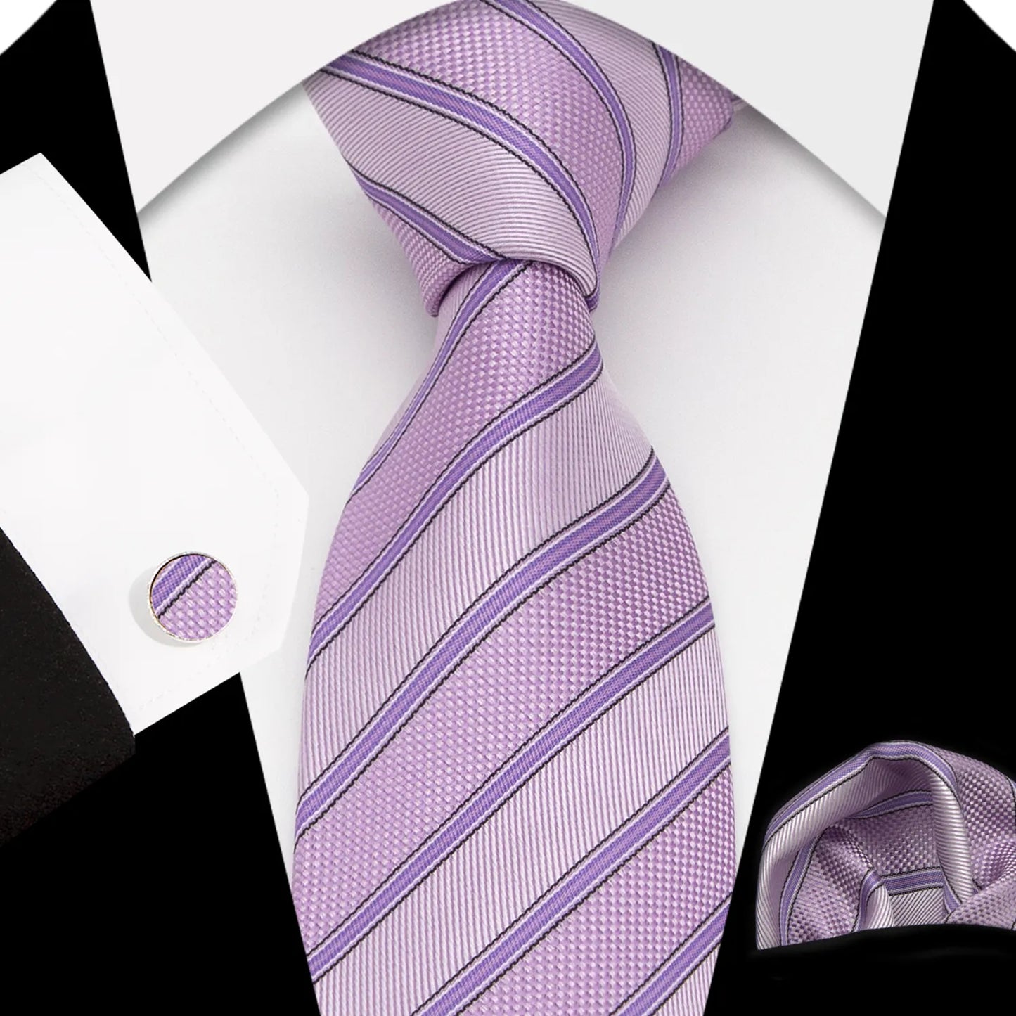 A complete men's tie set laid out, featuring a rich purple-pink (berry/amethyst) necktie with classic diagonal stripes in deep charcoal grey, a matching pocket square, and a pair of sleek silver-toned cufflinks, suggesting a bold and sophisticated formal or semi-formal look.