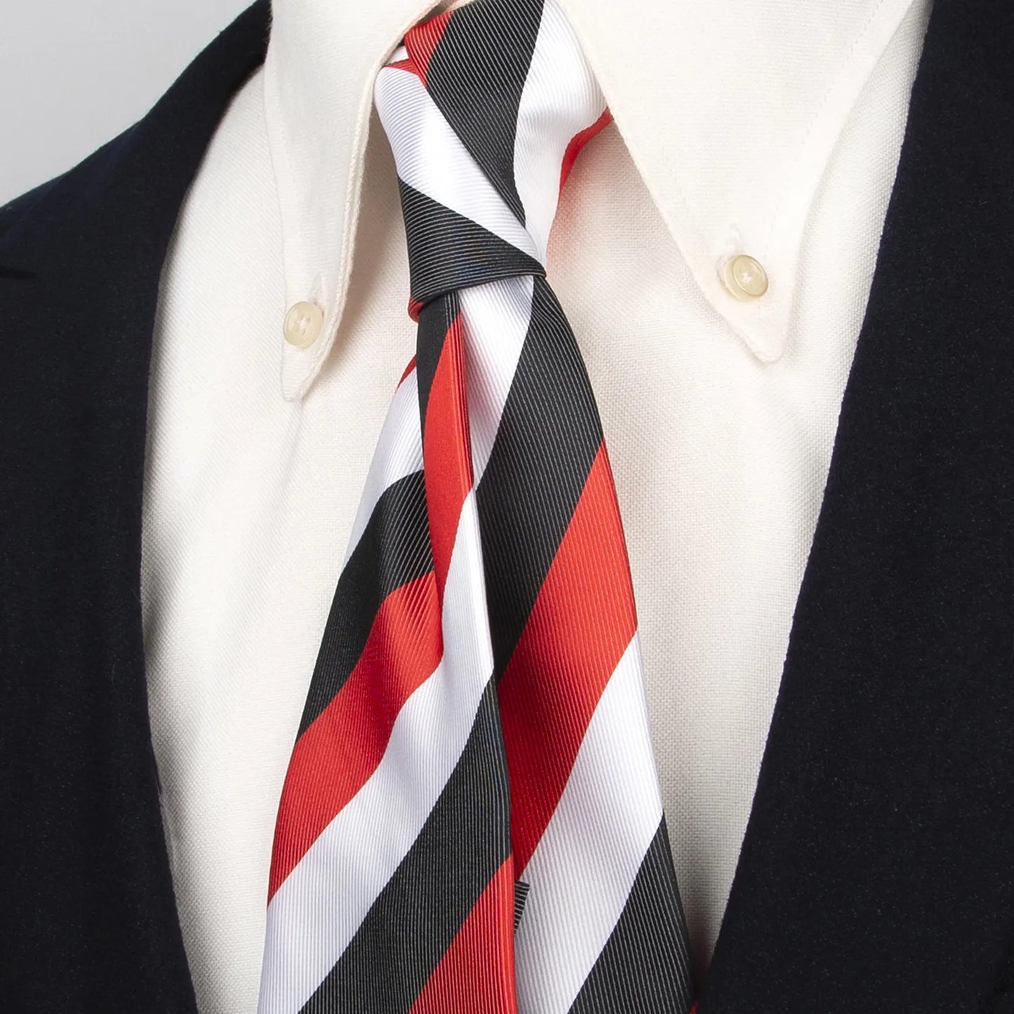 Close up of a bold men's tie featuring striking diagonal stripes in black white and red perfectly balanced for a dynamic look