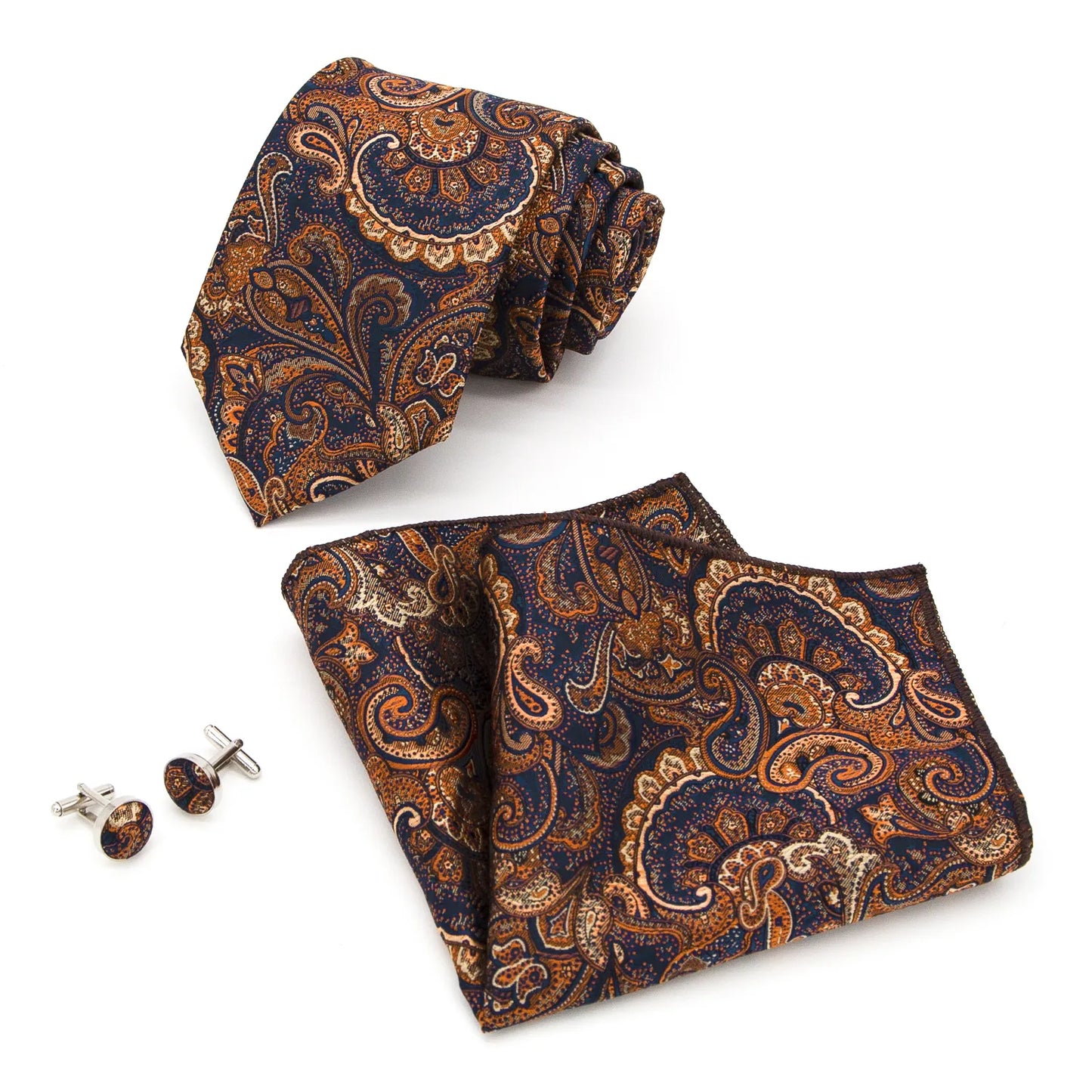 A coordinated set featuring a rolled navy blue and orange paisley polyester tie, a folded matching pocket square, and two round cufflinks, all displaying an intricate pattern on a white background.
