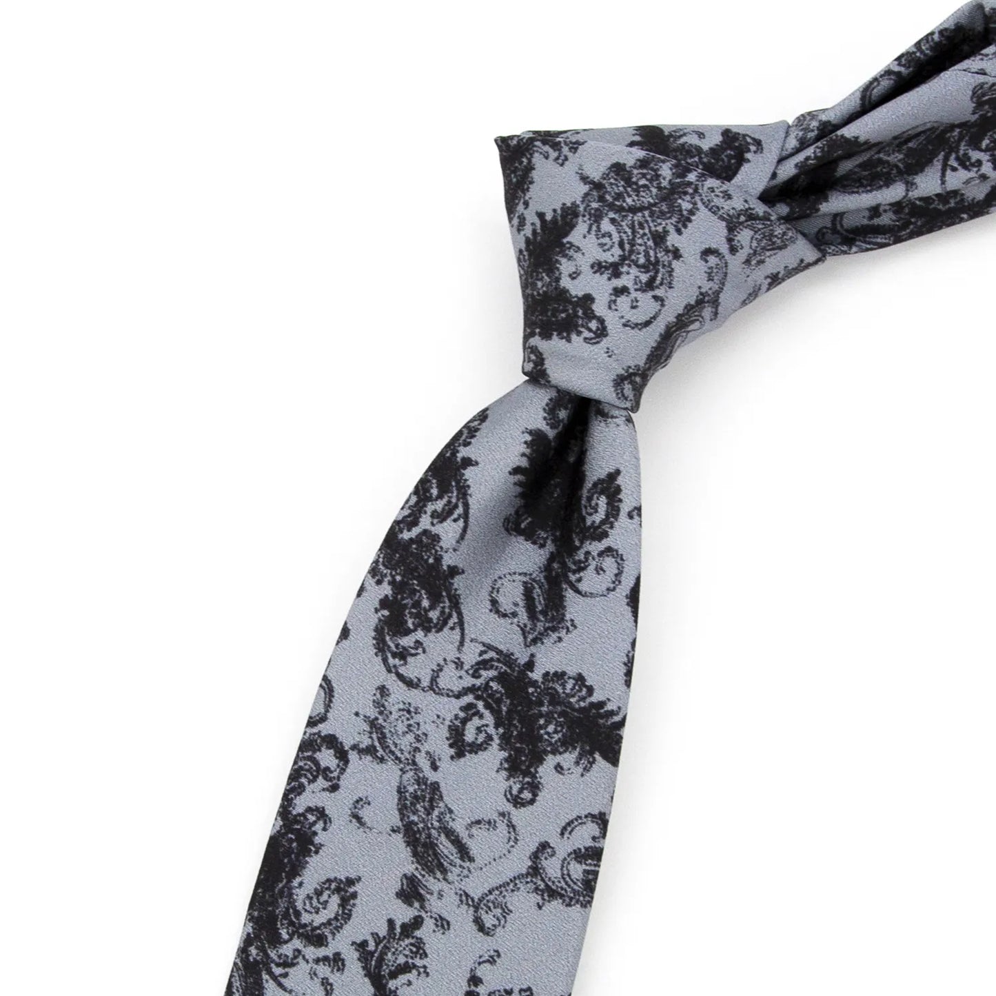 A neatly folded light grey men's necktie from XueDouLing Tie showcasing its refined black paisley pattern against a plain white surface.