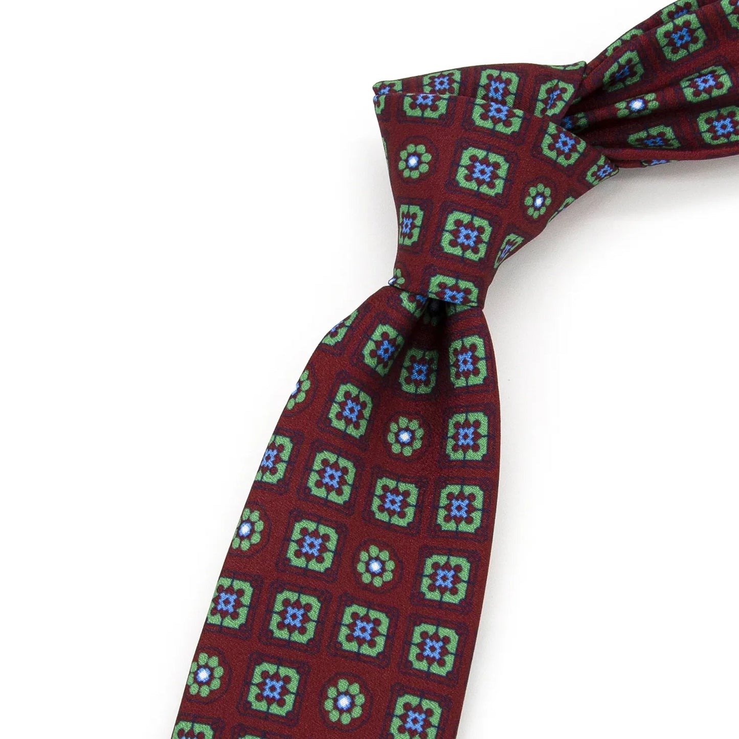A neatly folded burgundy men's necktie showcasing its detailed geometric floral pattern in green and blue against a clean white surface.