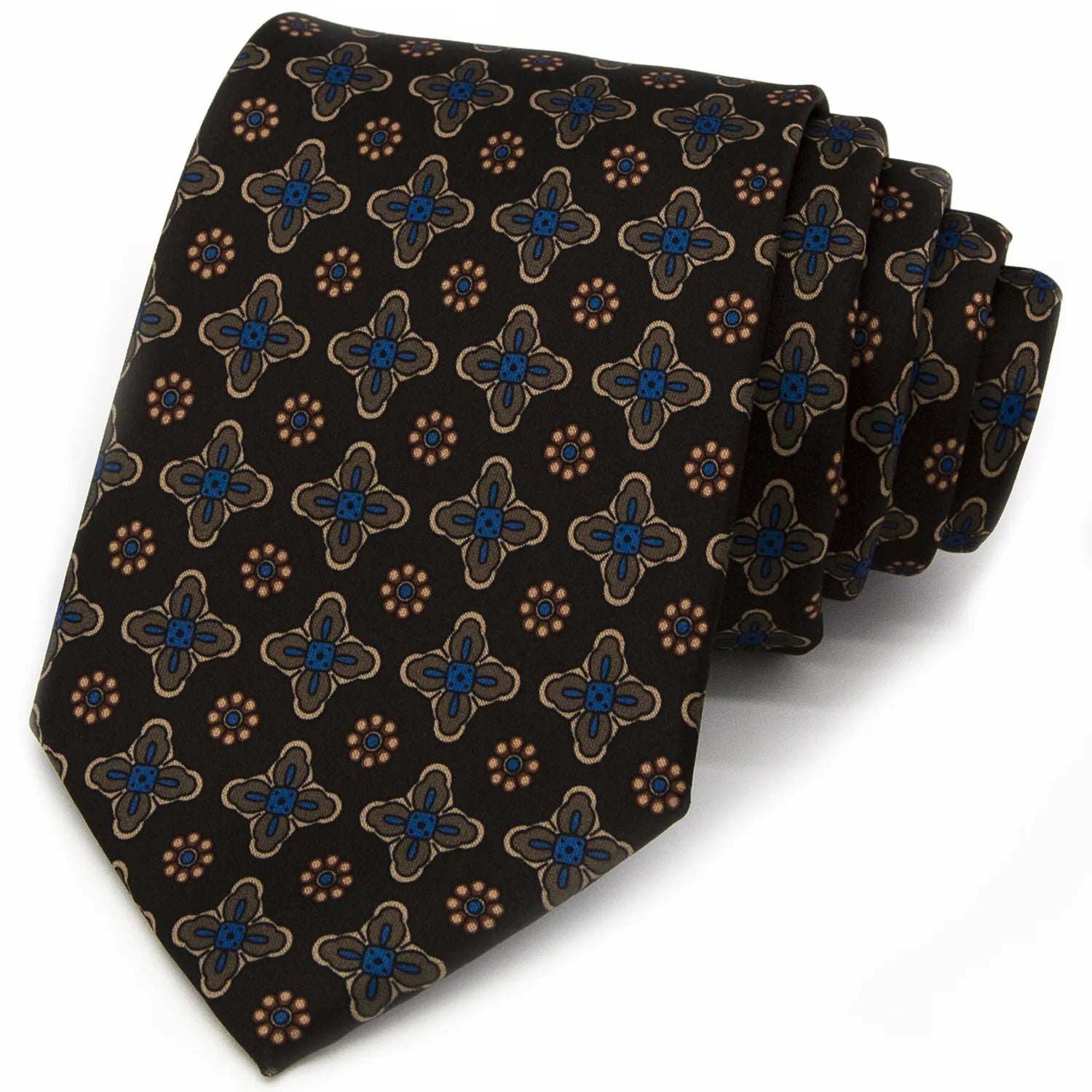A dark brown men's necktie featuring a repeating pattern of small blue, beige, and brown floral and geometric elements is tied in a four-in-hand knot on a crisp white button-down shirt, suitable for business and professional settings.