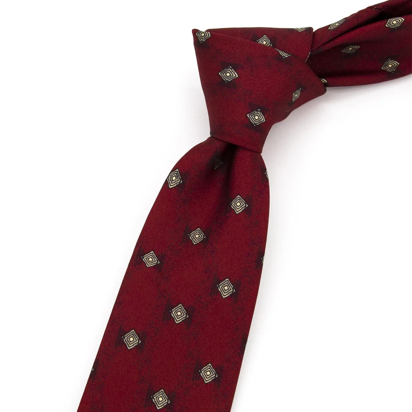 A neatly folded deep red men's necktie showcasing its intricate geometric diamond pattern in beige and black against a clean white surface.
