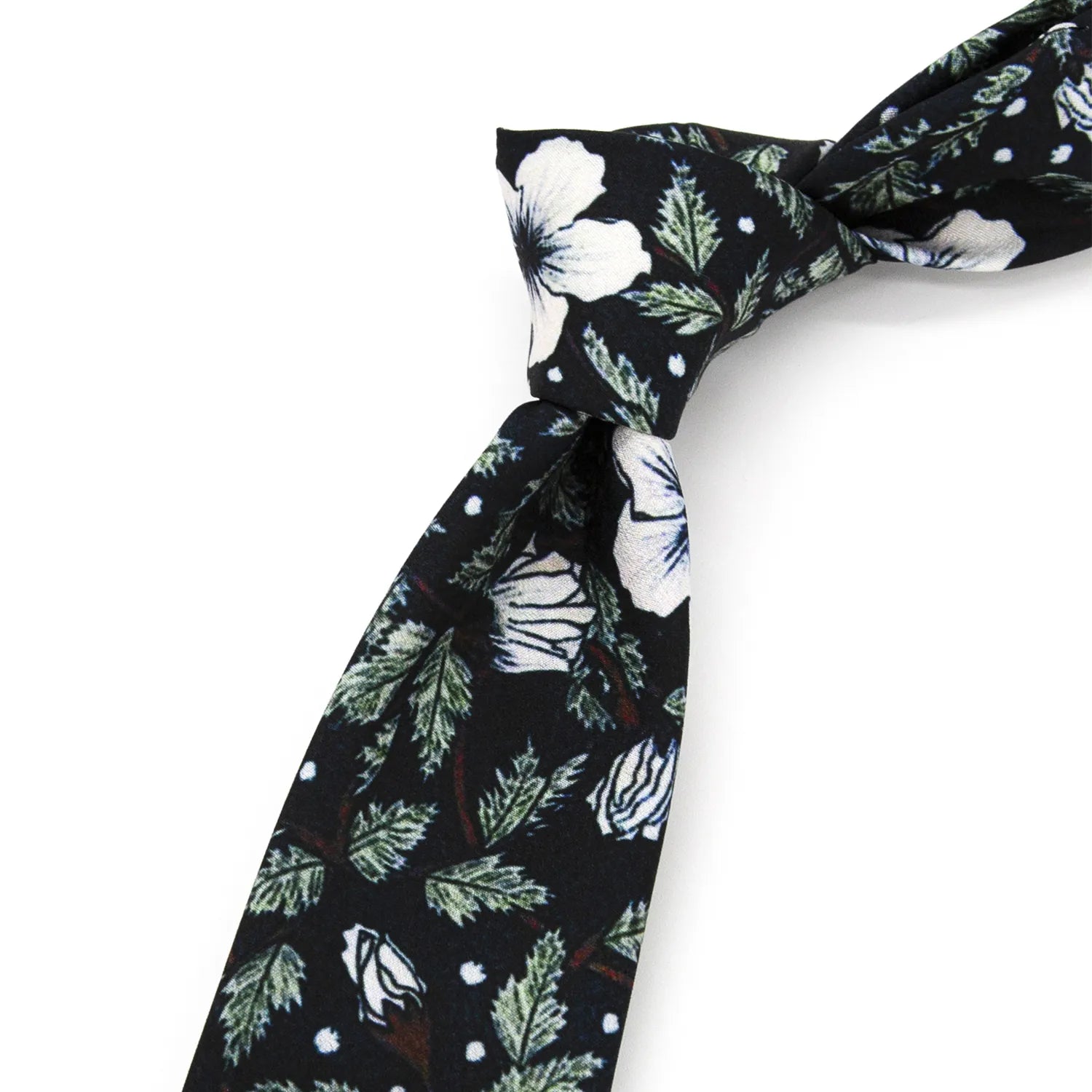 A neatly rolled deep black men's necktie displaying its minimalist floral pattern with white blossoms, green leaves, and white dot accents against a clean white surface.
