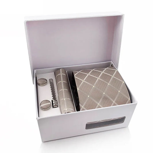 A complete men's tie set laid out, featuring a deep brown necktie with a luxurious golden diamond and dot pattern, a matching pocket square, and a pair of sleek silver-toned cufflinks, suggesting a sophisticated and warm business or formal look.
