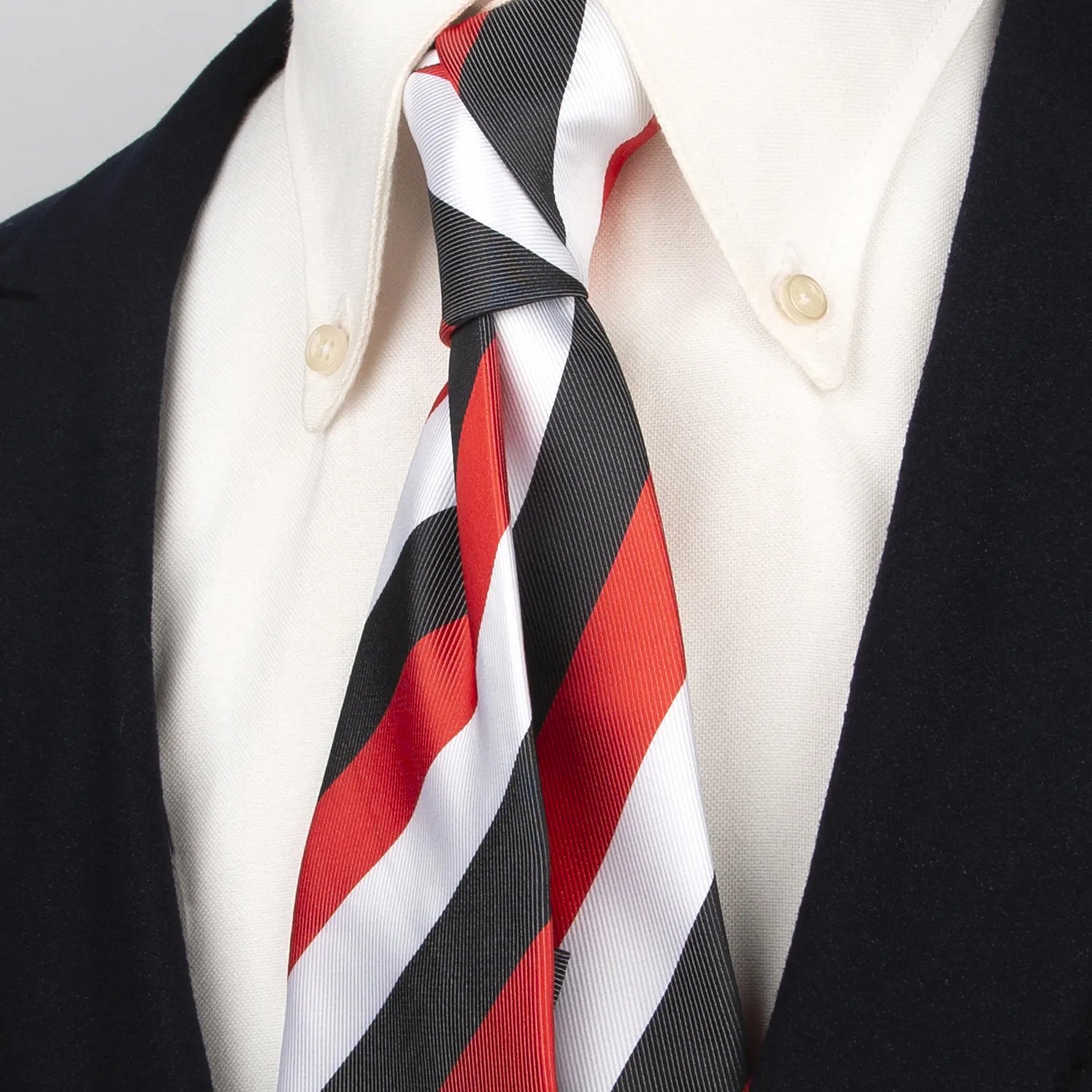 Close up of a bold men's tie featuring striking diagonal stripes in black white and red perfectly balanced for a dynamic look
