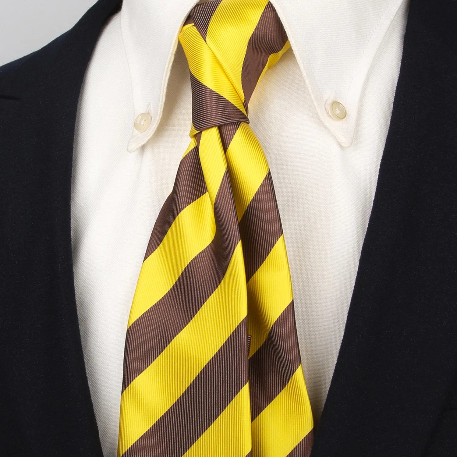 Full view of a luxurious men's tie displaying its refined diagonal stripes of vibrant yellow and warm brown highlighting the full pattern and quality of the fabric against a light background ready for wear