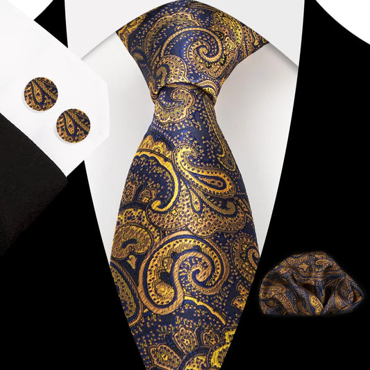 Close-up of a luxurious navy blue and gold paisley silk tie, perfectly knotted, with matching pocket square and cufflinks visible, styled for formal occasions.