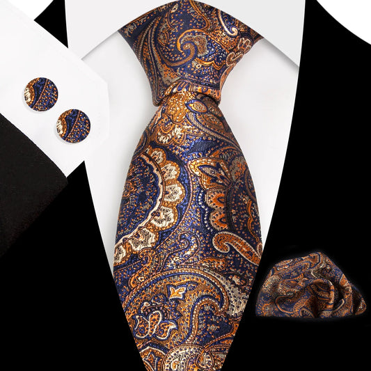 A close-up view of a stunning navy blue and rich orange paisley patterned polyester tie, neatly tied, complete with a matching pocket square and cufflinks, styled for a formal occasion.