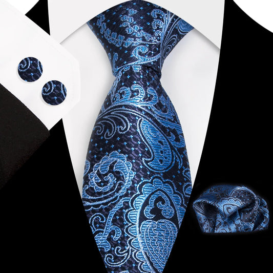 A close-up view of a vibrant blue and navy paisley patterned polyester tie, neatly tied, complete with a matching pocket square and cufflinks, styled for a formal occasion.