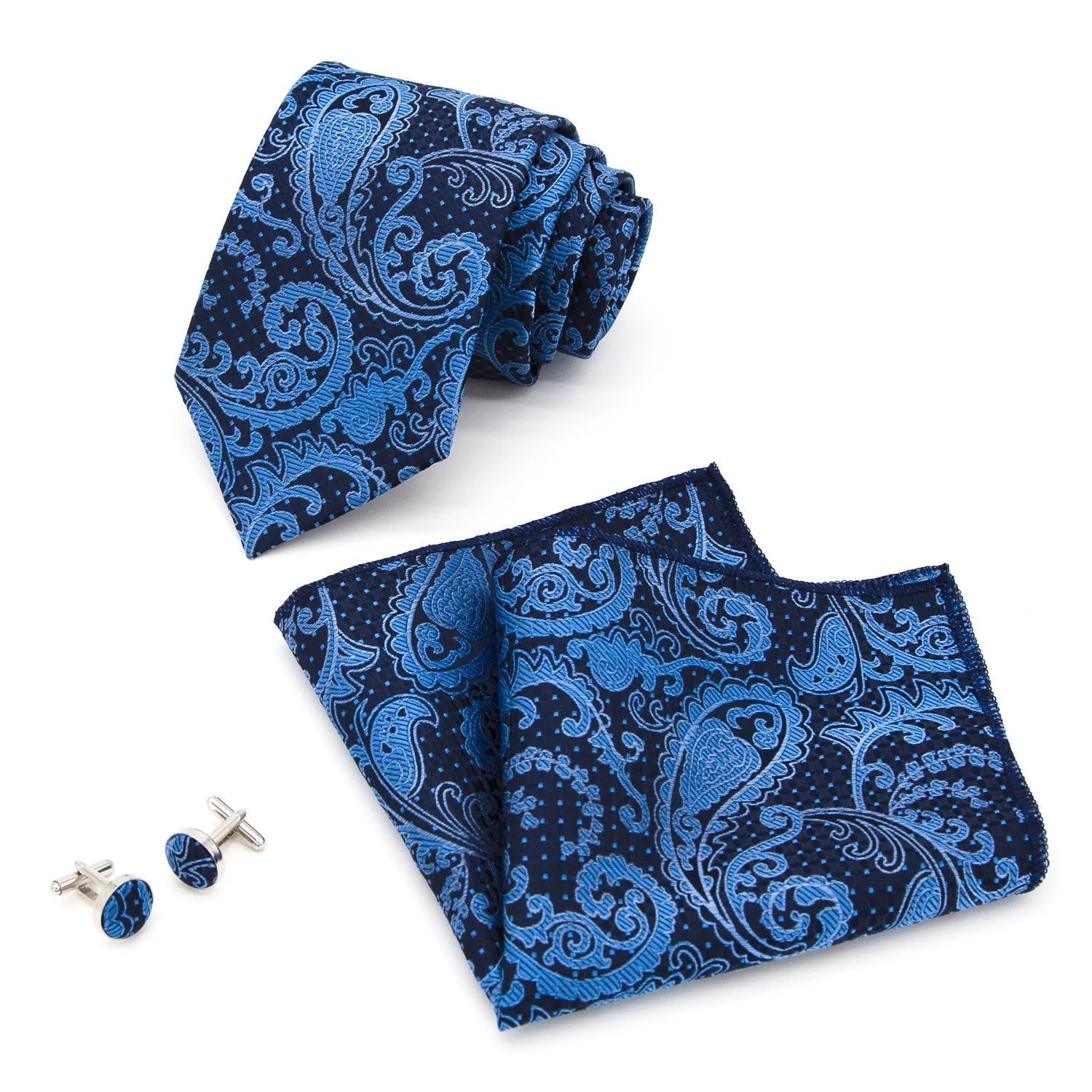 A coordinated set featuring a rolled blue and navy paisley polyester tie, a folded matching pocket square, and two round cufflinks, all displaying an intricate pattern on a white background.