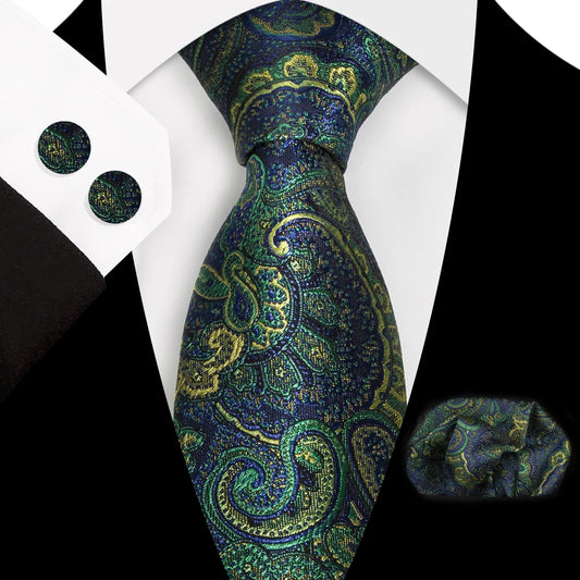 A close-up view of a striking navy blue and vibrant green paisley patterned polyester tie, expertly knotted, complete with a matching pocket square and cufflinks, styled for a formal occasion.